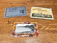 Three vintage postcard items laid out closed on wooden floor
