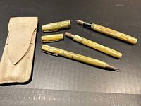 Full view of fountain pen parts, mechanical pencil and leather pouch