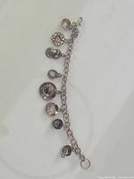 Full view of sterling silver charm bracelet showing chain and seven dangling charms