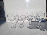 Four stemmed wine glasses displayed upright