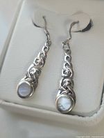 Close up of both earrings showing Celtic knot shafts and mother of pearl inlays