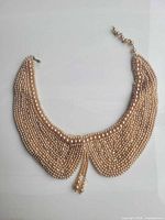 Front view of collar showing dense faux pearl bead strands and overall shape