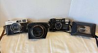 Canon rangefinder camera, Canon leather case, Minolta AF camera, Minolta case