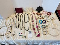 overview of all jewelry and three clutch purses on table