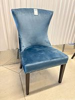 front three-quarter view of blue velvet wingback dining chair