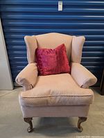 Front view of upholstered wingback chair with cushion