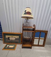group shot of shelf stand, mirror, lamp, and two framed prints