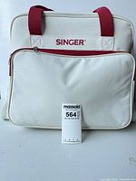 Singer branded carrying case with red handles and front pocket