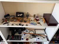 Two shelf view showing keychains, lighters, pocket knives, binoculars, magnifiers and accessories