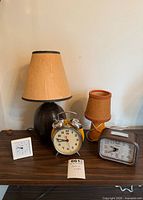 Group view of two lamps and three alarm clocks on table