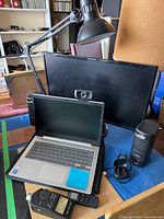 Group shot showing laptop, monitor, speakers, lamp, webcam, earbuds, sound meter