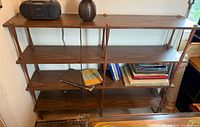 Front view of four-tier spindle bookshelf with faux walnut laminate shelves and wood spindle uprights