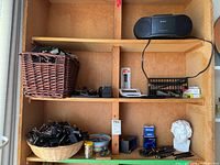 Shelf with Sony radio, basket of binder clips, pens, wire rack of clips, Beethoven bust