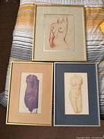 Group shot of all three framed artworks on bed