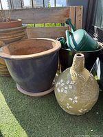 Overall view of planter, vase, pail and watering cans