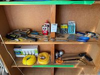 Overall view of shelf with tools, rope, bulbs and hardware