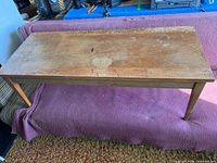 Full view of rectangular wooden coffee table on purple blanket