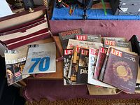 Open briefcase with magazines arranged on table