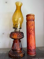 Amber glass oil lamp and carved candle full view