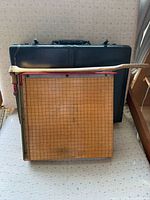 Paper cutter on top of black briefcase, showing overall items