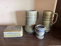 Group shot of two steins, trinket box and mini urn