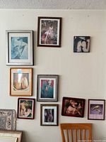 Wall displaying arrangement of nine framed nude art pieces