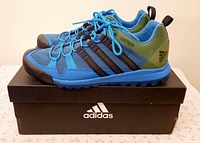 Side view of both Adidas Terrex Solo sneakers on box