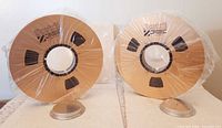 Front view of the two sealed gold metal Scotch video tape reels