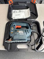 Sander inside open carry case with manual and power cord visible