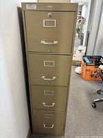 front view of file cabinet showing four drawers, handles, label frames, lock
