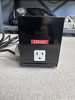 Front view showing 230 VAC outlet on black housing