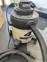 Front view of Shop-Vac showing 4-gallon marking, hose, caster base