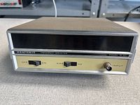 Front view showing display window, switches, input jack and model designation