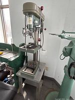 Full view of JET drill press on stand with vise and drill bits