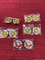All ten pins in five sealed pairs laid out on red fabric