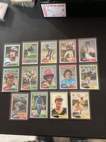 Group shot of 14 sleeved 1981 Topps cards laid out on table