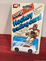 Front of sealed Corgi Hockey Trading Cars blister card showing white Porsche Carrera and NHL artwork
