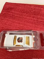 Angled overhead view of blister-packed white Mustang Cobra die-cast car showing NHL logo and yellow windows