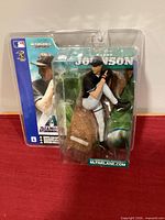Front view of sealed Randy Johnson McFarlane Sportspicks figure on red surface