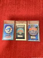 Front view of three Toronto Blue Jays pocket schedules from 1992, 1993, and 1994 in plastic cases