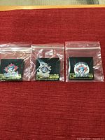Three sealed Blue Jays pins on cards