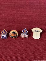 All four MLB lapel pins side by side on red fabric