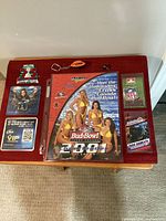 All items laid out on table: calendar, keychain, pin, coasters, schedules, Grey Cup badge