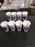 Front view showing player portraits on all eight cups