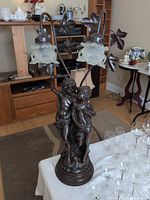 Front view of bronze-finish Art Nouveau table lamp with children figures and two visible frosted glass shades