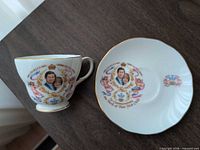 Teacup and saucer showing full portrait design and gold trim