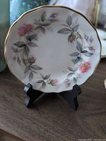 Front view of plate showing Bramble Rose floral pattern and gold-trim scalloped edge