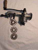 Full view of Keystone meat grinder with handle, clamp and three plates