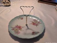 Full view of cake plate with metal handle showing floral pattern