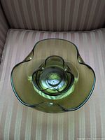Top view showing both nested olive green glass bowls and ruffled floral rims